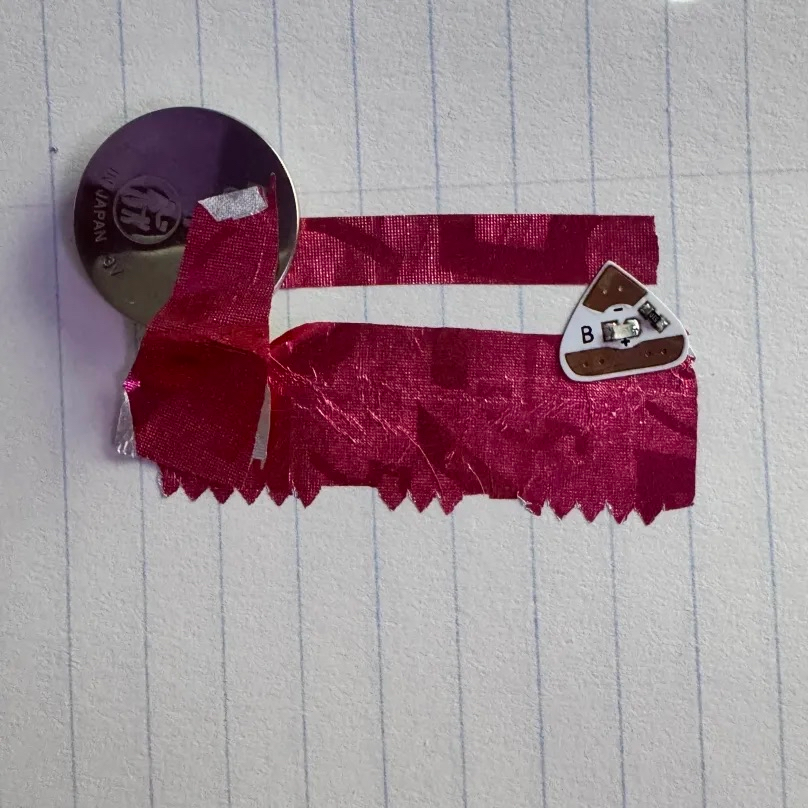 While chewing gum, I wondered if the gum wrapper would be conductive enough to work like the copper tape does. It didn't work with just one battery though...