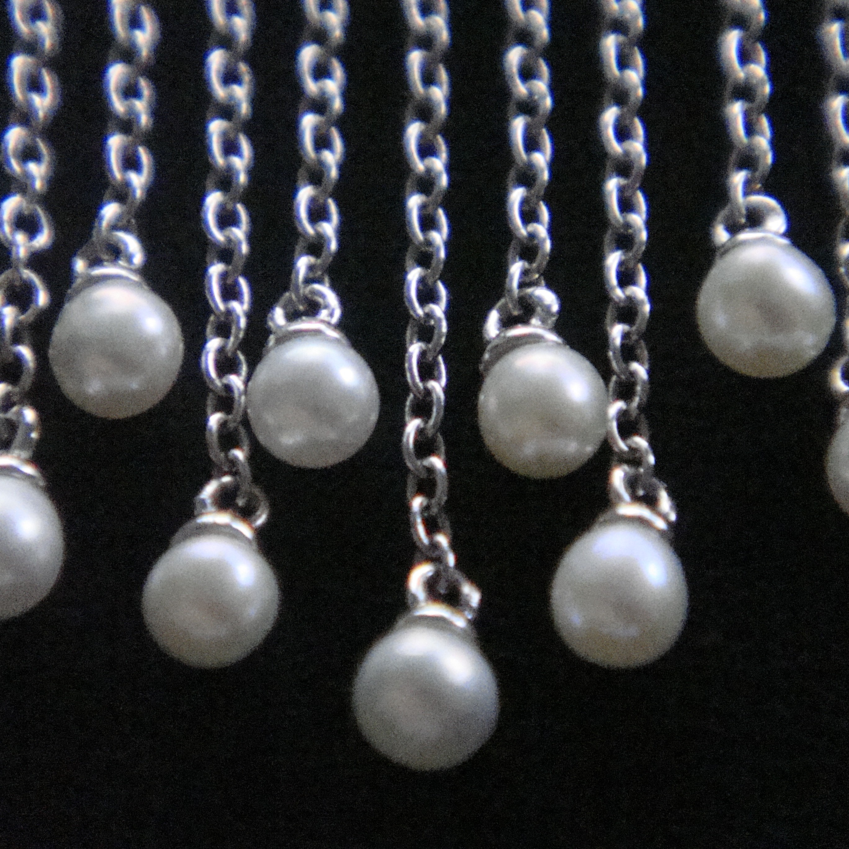 The ends of its chains are decorated with pearls.